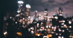 blurry image of city lights in the night sky from above, with dark clouds