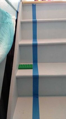 the stairs are painted blue and white with stripes on them, as well as a green brush