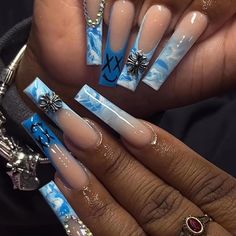 a person with blue and white nail designs on their nails