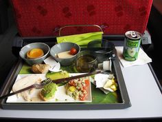 the tray is full of food and drinks on the table in the seat area,