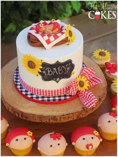 a baby shower cake with sunflowers and cupcakes