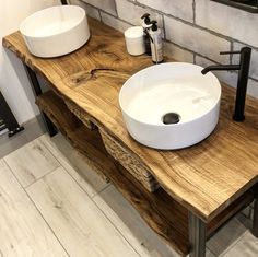 two white sinks sitting on top of a wooden counter