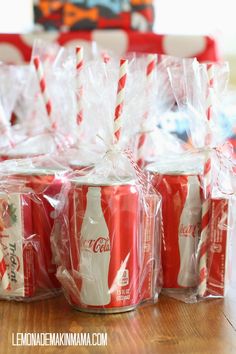 coca - cola cans wrapped in plastic and sitting on a table with candy canes