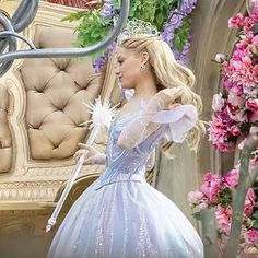 there is a woman dressed in a princess dress and holding a wand next to a bench