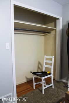 a white chair sitting on top of a hard wood floor next to a wooden shelf