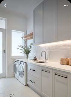 a white kitchen with a washer and dryer in it