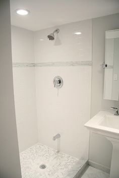 a white bathroom with a shower and sink