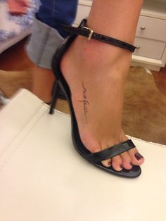 a woman's foot with a tattoo on her left ankle and the word love is written in cursive writing