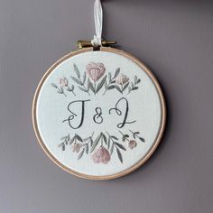 embroidered monogrammed wall hanging with flowers and the letter j & p on it