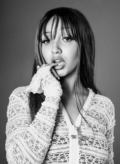 a black and white photo of a woman holding her hand to her mouth while posing for the camera