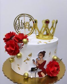 a white cake with gold decorations and red flowers