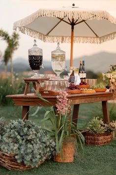 a picnic table with an umbrella over it and some flowers on the ground next to it