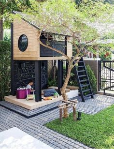 a small wooden house with stairs to the second floor and an outdoor play area for children