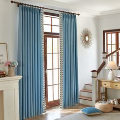 a living room filled with furniture and blue curtains