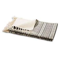 two black and white towels folded on top of each other, one with fringes