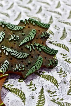 a piece of metal with green leaves on it