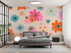 a bed sitting in a bedroom next to a wall with flowers painted on the walls