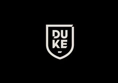 a black and white photo with the words duke on it's side, in front of a shield