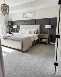 a bedroom with a bed, nightstand and chandelier