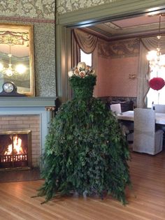 a living room with a fire place and christmas tree in the middle of the room