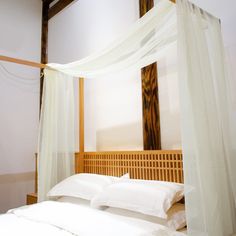 the bed is made with white sheets and pillows