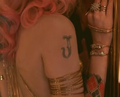 a woman with pink hair and tattoos on her arm