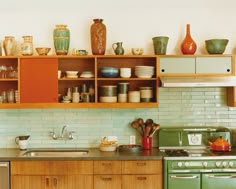 a kitchen filled with lots of different types of dishes and vases on top of wooden shelves