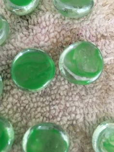 several green glass bottles sitting on top of a carpet