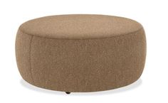 a brown ottoman sitting on top of a white floor