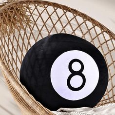 a black and white ball sitting on top of a wicker chair