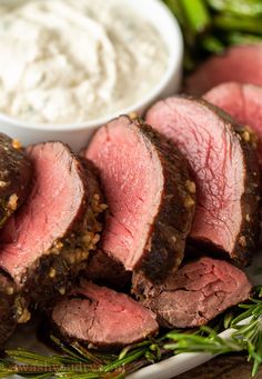 slices of roast beef on a plate with dip