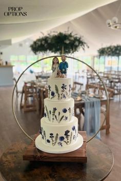 a three tiered wedding cake with figurines on top