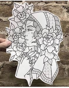 a woman with flowers on her head holding up a sticker in front of a brick wall