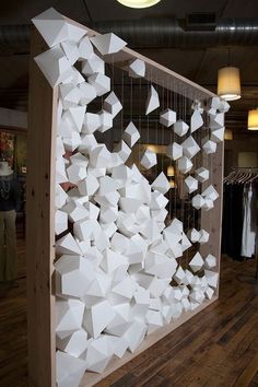 a room filled with lots of white cubes on top of a wooden floor next to a window