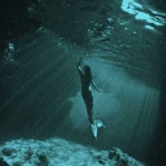 a woman is swimming in the ocean at night