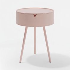 a small round table with wooden legs and a pink top on an isolated white background