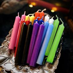 many different colored candles are in a holder