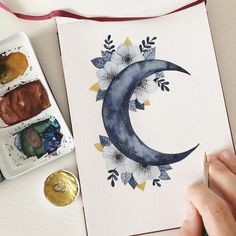 someone is painting the moon with watercolors on paper