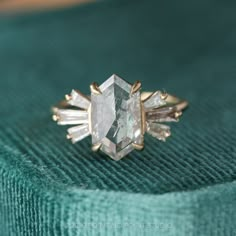 a diamond ring sitting on top of a green cloth