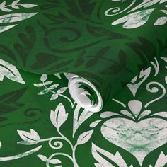 a green and white wallpaper with an ornate design on the back side of it