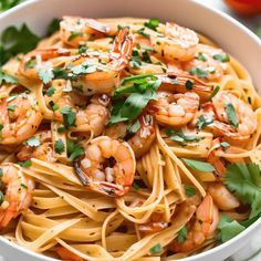 pasta with shrimp and parsley in a white bowl