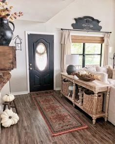 a living room filled with furniture and a large window next to a wooden floor covered in white pumpkins