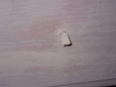 a small white object on the side of a wall