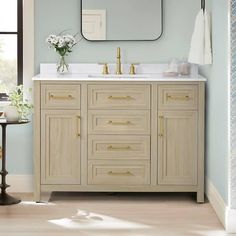 a bathroom vanity with two sinks and a large mirror above it, in front of a window