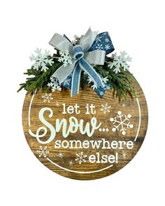 a wooden sign that says let it snow somewhere else