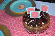 there is a cake with chocolate candies on it and place cards in the middle