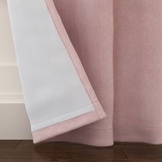 closeup of pink and white bedding with wood flooring