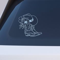 a sticker on the side of a car that has a cowboy boot and flowers in it