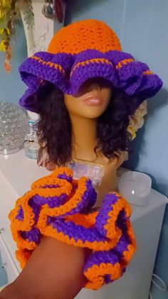 a mannequin wearing a purple and orange crochet hat on top of a white toilet