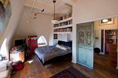 a bedroom with a bed, bookshelf and other items in the room on the floor